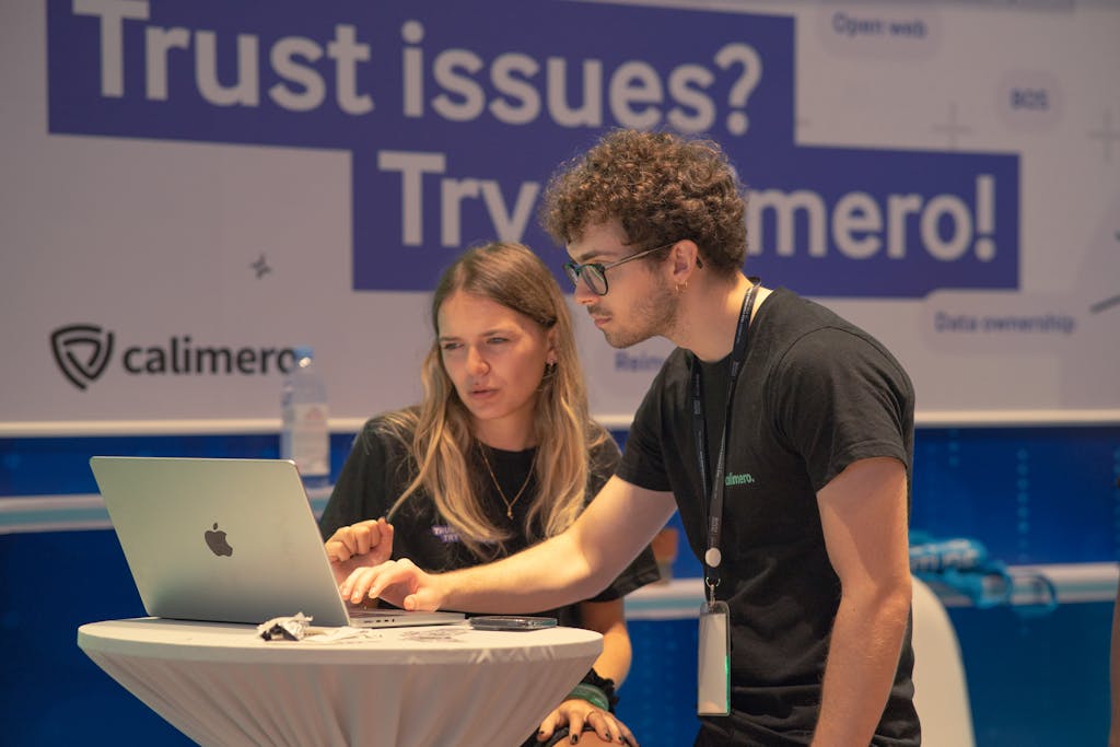 Two people sitting at a table with a laptop