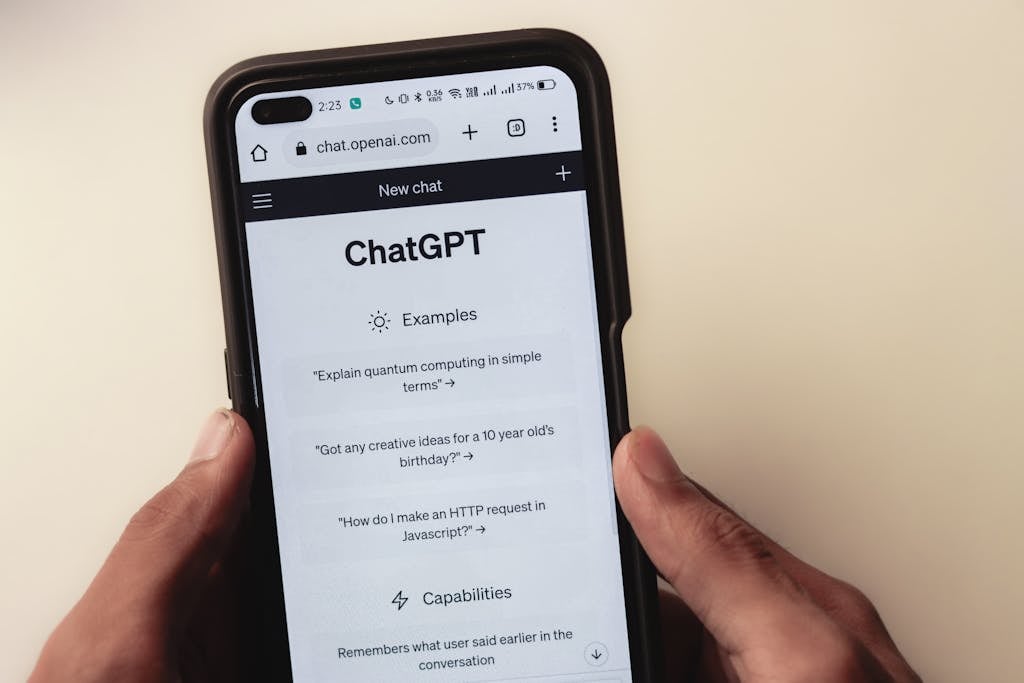 Webpage of ChatGPT, a prototype AI chatbot, is seen on the website of OpenAI, on a smartphone. Examples, capabilities, and limitations are shown.